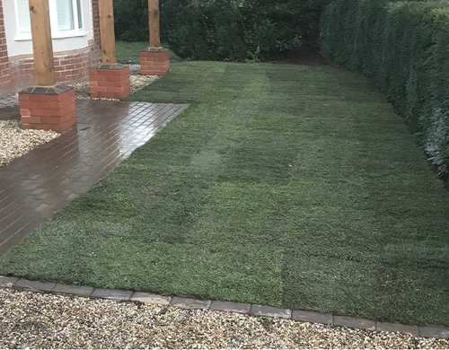 New front garden lawn turfed, framed by gravel and paving. 